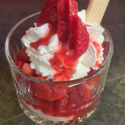 Erdbeerbecher mit frischen Erdbeeren und selbstgemachter Soße